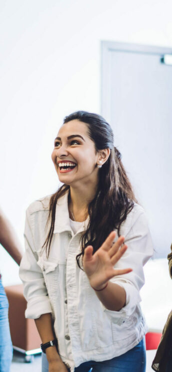 Une jeune souriante au tableau de la classe qui suit une formation disc